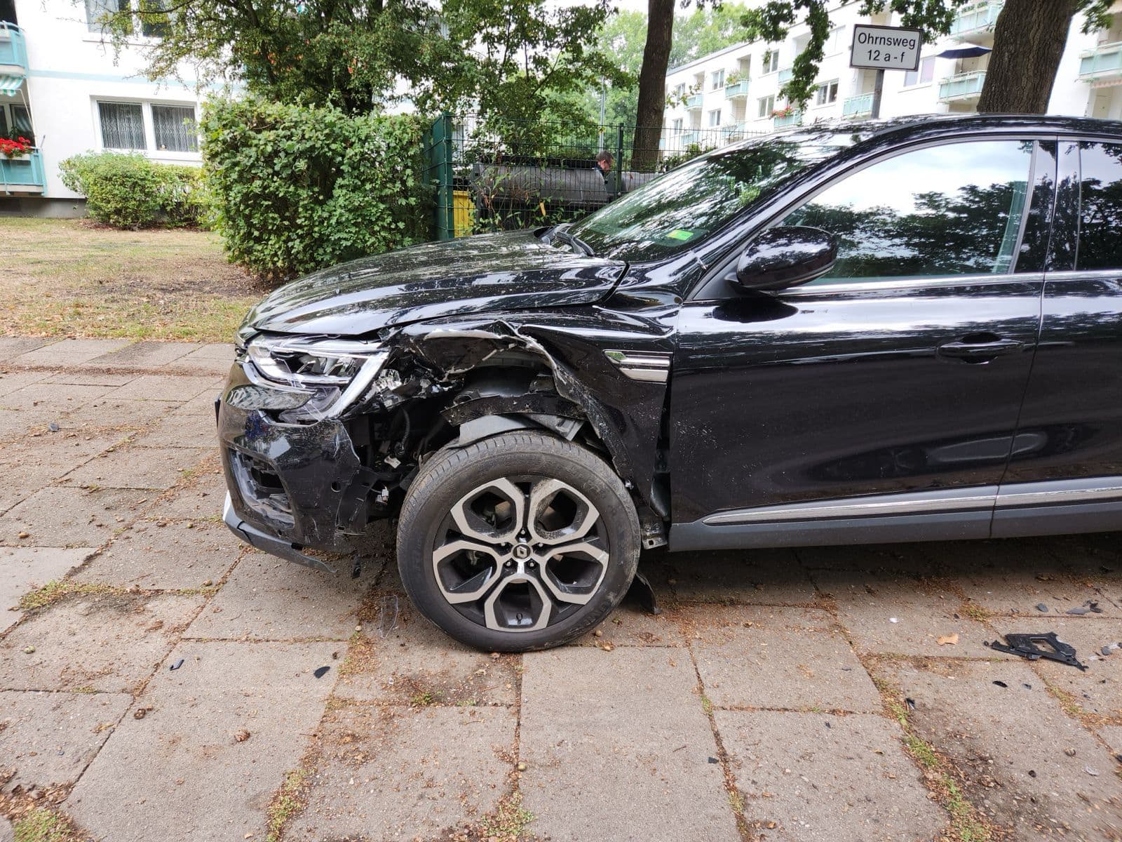 Schwarzer Pkw mit eingedrücktem Vorderwagen und verschobenem Vorderrad