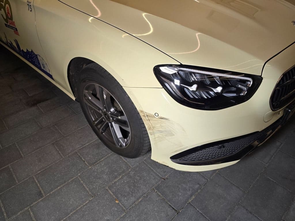 Taxi mit Schäden an Front und vorderem Kotflügel